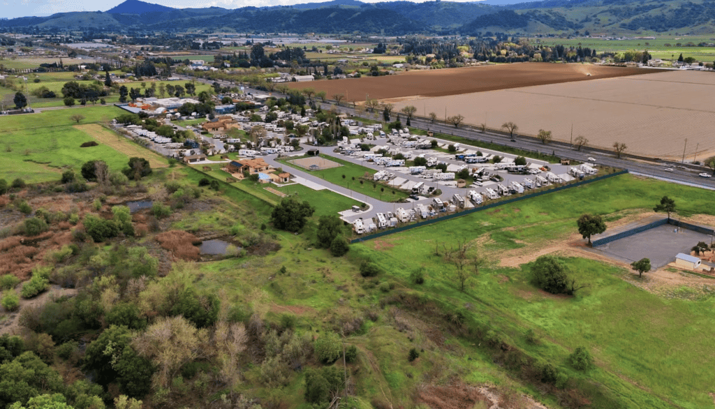 Spacious RV campground with multiple trailer spaces, scenic green surroundings, recreational amenities, and nearby natural landscapes, ideal for outdoor enthusiasts and RV travel.