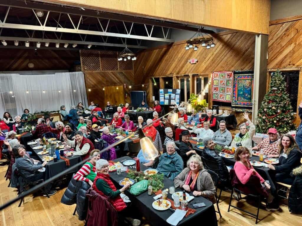 Enjoying RVing, traveling, camping, nature at a gathering of women in a large indoor space.