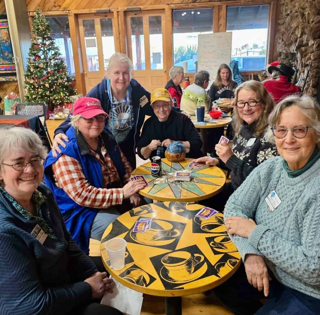 Enjoying RVing, traveling, camping, nature with a group of women at a cozy indoor gathering during a camping trip.